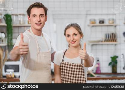 Caucasian couple or lovers doing Like action when taking photo or selfie when cooking breakfast together in kitchen,just married and sweet honeymoon,video social network,vlog and Influencer concept