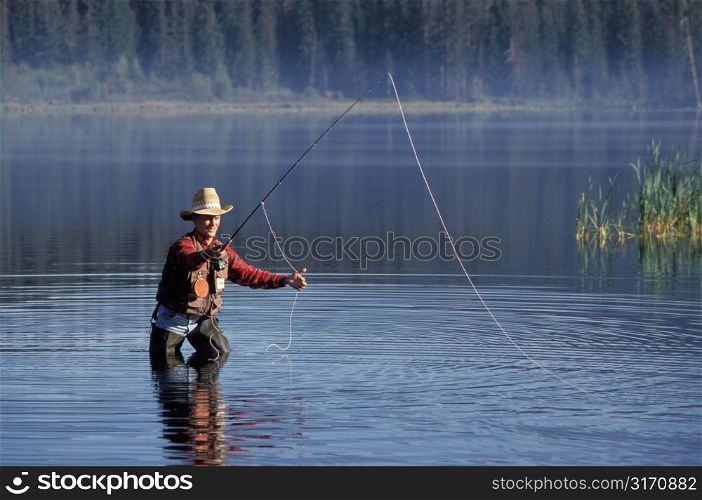 Caucasian Cowboy Fly Fishing In A Mountain Lake