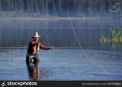 Caucasian Cowboy Fly Fishing In A Mountain Lake