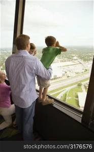 Caucasian family looking out observation deck at Tower of the Americas in San Antonio, Texas.