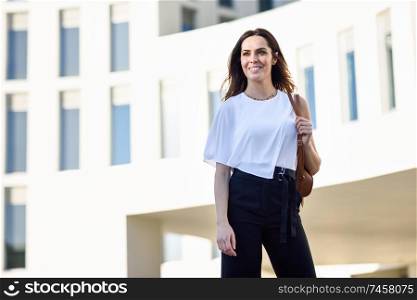 Caucasian female entrepreneur in formal clothes. Confident businesswoman standing outside an office building.. Confident businesswoman standing outside an office building.