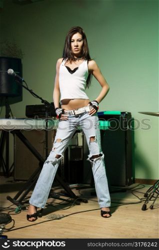 Caucasian female posing with musical equipment.