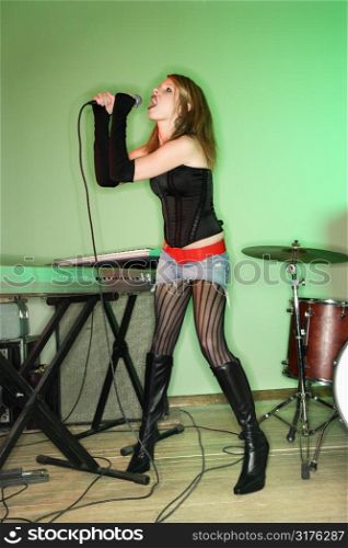 Caucasian female singing into microphone.