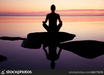 caucasian fitness woman practicing yoga on the beach at sunset. caucasian fitness woman practicing yoga