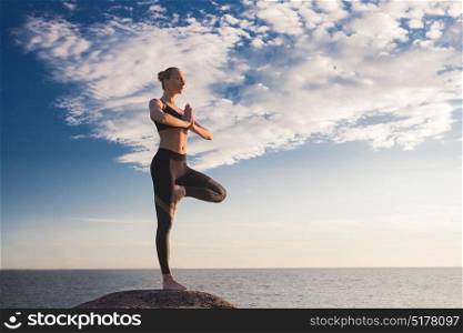 caucasian fitness woman practicing yoga. young caucasian fitness woman practicing yoga at sea shore