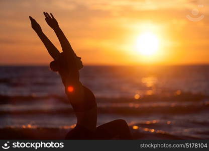 caucasian fitness woman practicing yoga. young caucasian fitness woman practicing yoga at sea shore