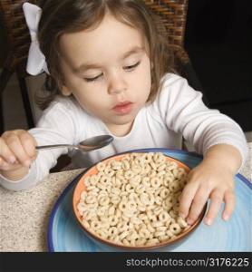 Caucasian girl eating bowl of cereal.