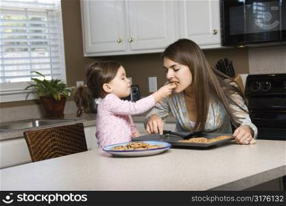 Caucasian girl feeding mother cookies.