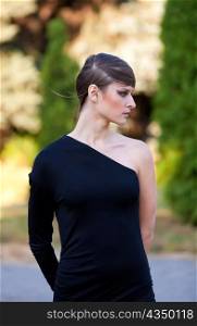 Caucasian girl in black dress with one cut sleeve outdoor
