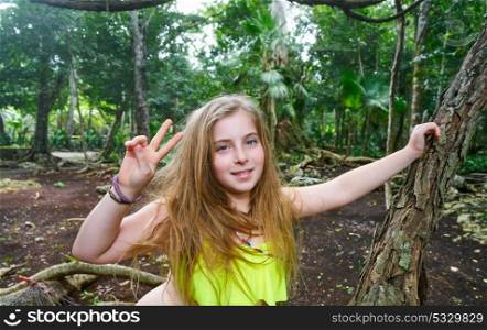Caucasian girl playing victory sign in the rainforest jungle