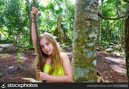 Caucasian girl playing with lianas in the rainforest jungle
