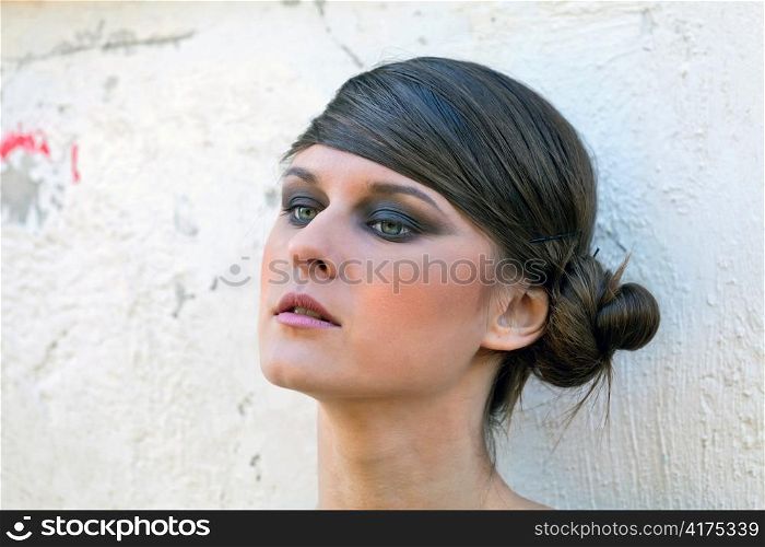 Caucasian girl portrait with makeup on white wall background