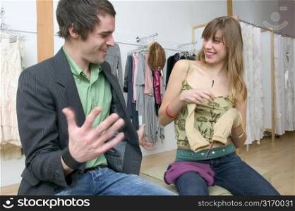 Caucasian Girl Sitting In A Trendy Boutique And Flirting With A Boy