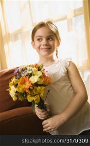Caucasian girl smiling holding bouquet of flowers.