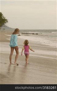 Caucasian girls walking down beach