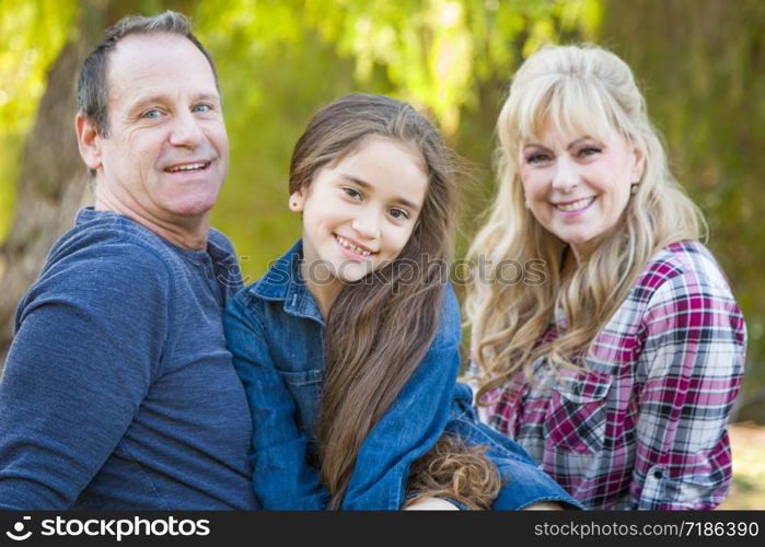 Caucasian Grandmother and Grandfather With Young Mixed Race Grandaughter Outdoors.