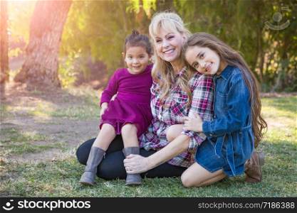 Caucasian Grandmother With Young Mixed Race Grandaughters Outdoors.