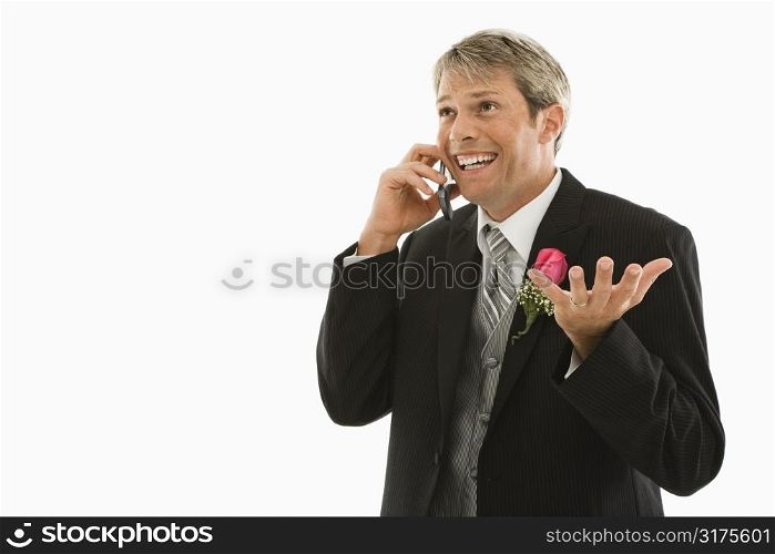 Caucasian groom talking on cellphone.