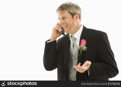 Caucasian groom talking on cellphone.