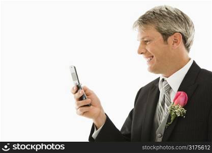 Caucasian groom using his cellphone.