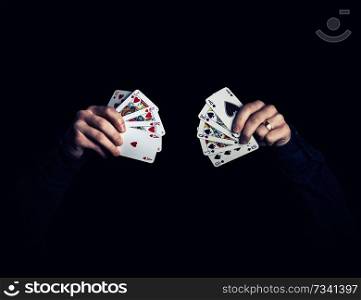 caucasian hands holding royal flush combination of hearts and spades