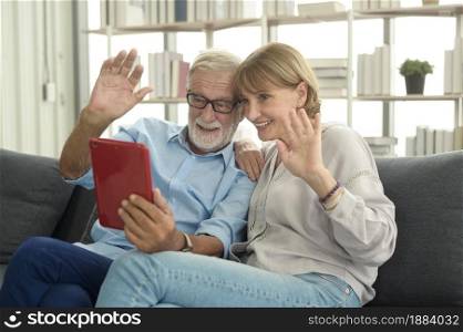 Caucasian happy seniors elderly are video calling to family or friends, relax at home, smiling healthy senior retired grandparents, older grandparent technology concept
