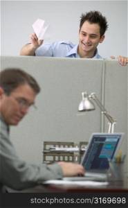Caucasian Male Office Worker Playing Pranks On His Cubicle Neighbor