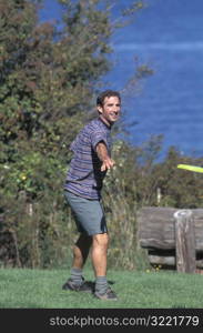 Caucasian Man Playing Frisbee Near A Lake