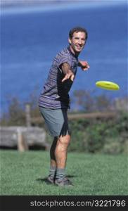 Caucasian Man Playing Frisbee Near A Lake