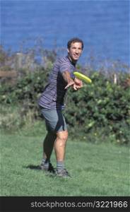 Caucasian Man Playing Frisbee Near A Lake