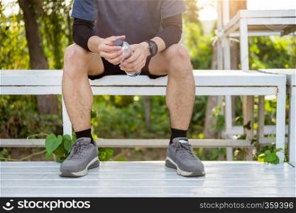 Caucasian man short beard drinking refreshing water while sitting and resting after workout exercises, health care concept