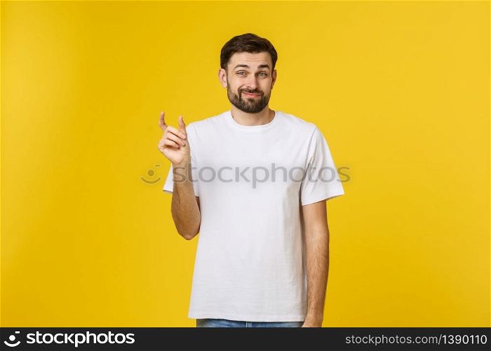 Caucasian man show small size by fingers demonstrate tiny measure, tell about little decreased prices. Studio shot yellow wall.. Caucasian man show small size by fingers demonstrate tiny measure, tell about little decreased prices. Studio shot yellow wall