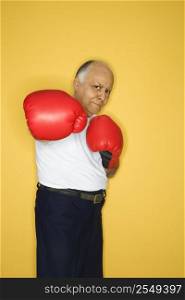 Caucasian mature adult male wearing boxing gloves.
