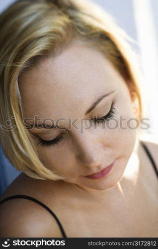 Caucasian mid-adult blonde woman looking down.