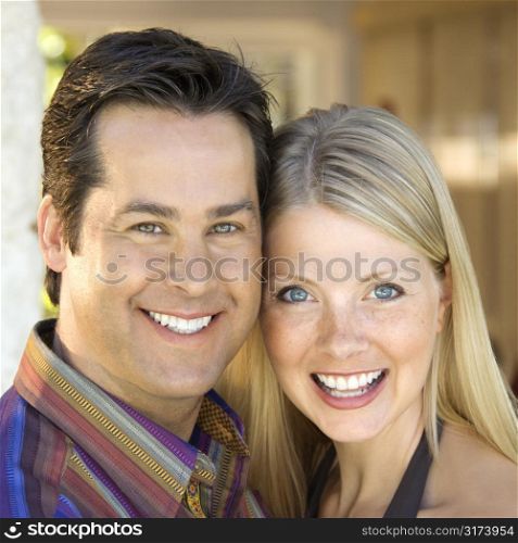 Caucasian mid adult couple smiling at viewer.