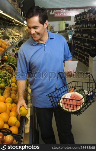 Caucasian mid-adult male grocery shopping for fruit.