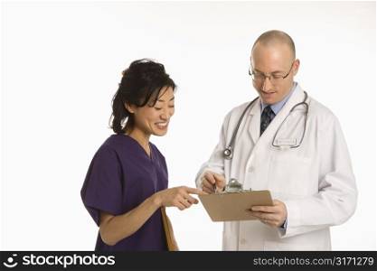 Caucasian mid adult male physician talking with Asian woman doctor.