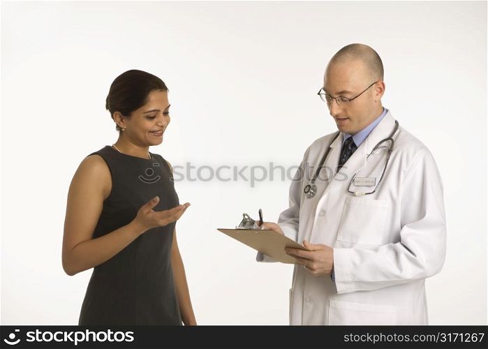 Caucasian mid adult male physician talking with Indian woman patient.
