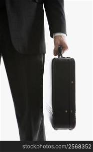 Caucasian mid-adult man&acute;s hand holding briefcase.