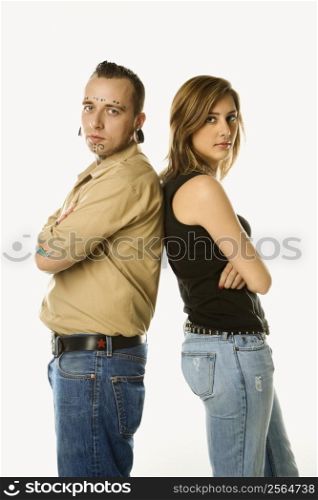 Caucasian mid-adult man and teen female standing back to back.