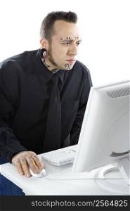 Caucasian mid-adult man with tattoos and piercings using computer.