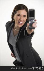 Caucasian mid adult professional business woman taking picture of self with camera phone and smiling.