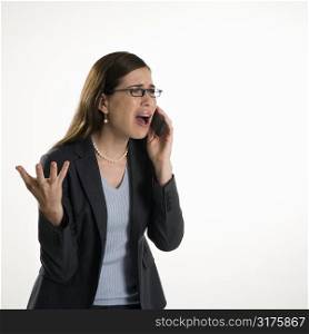 Caucasian mid adult professional business woman talking on cell phone with frustrated expression.
