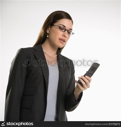 Caucasian mid adult professional business woman text messaging on cell phone.