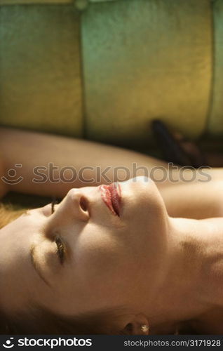 Caucasian mid adult woman lying on back with eyes closed.