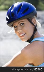 Caucasian mid-adult woman wearing bicycle helmet looking at viewer smiling.