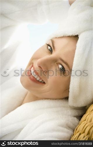 Caucasian mid-adult woman wearing towel on head smiling at viewer.