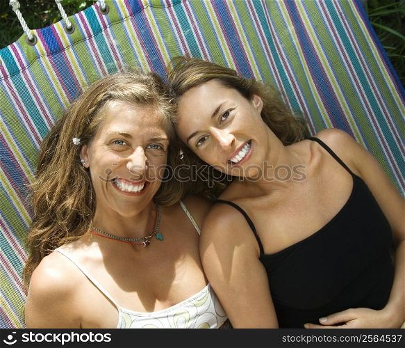 Caucasian mid-adult women lying in hammock and smiling.