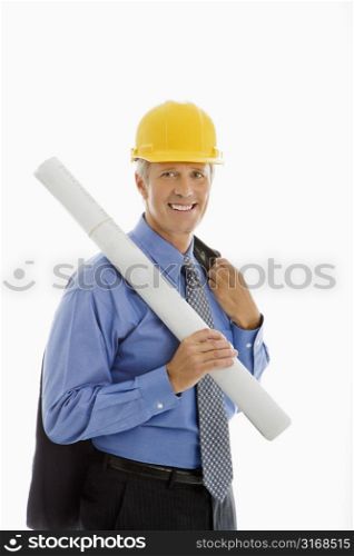 Caucasian middle aged businessman holding blueprints and wearing hard hat.