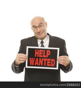 Caucasian middle-aged businessman holding help wanted sign.